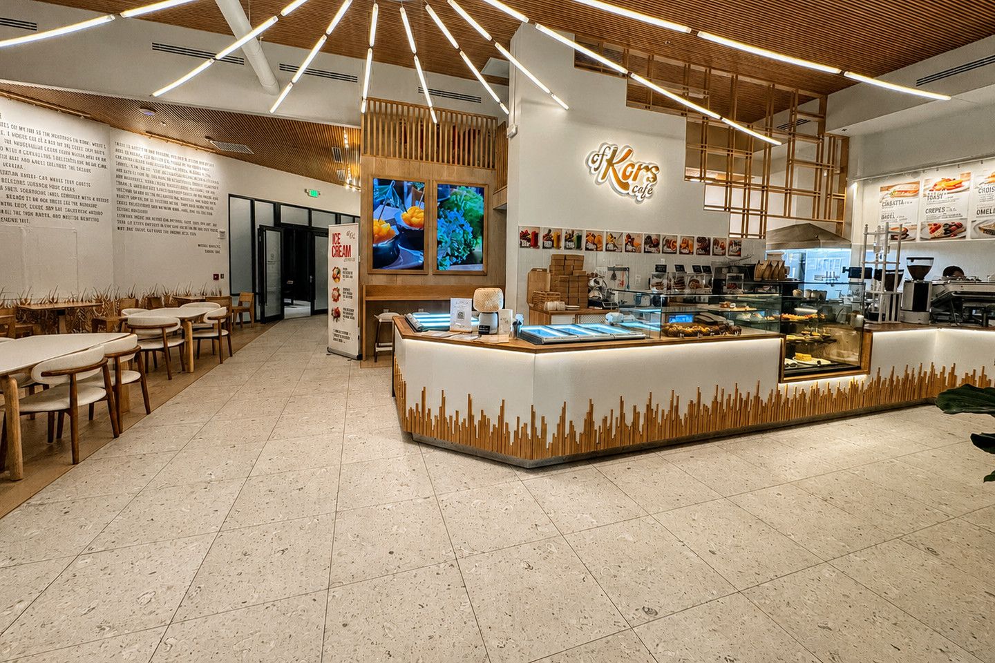 Café with a long counter, seating and a light speckled tile floor